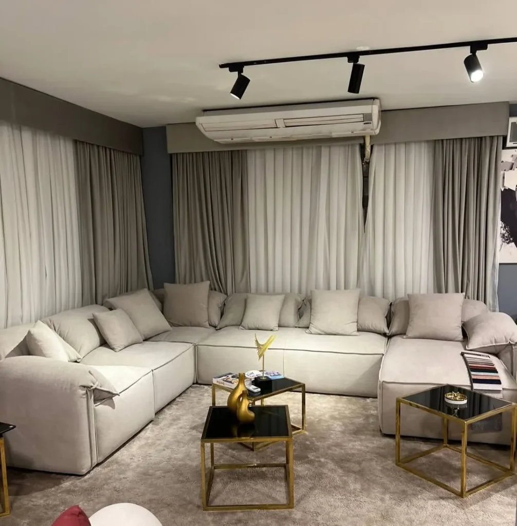 Modern living room furniture with large beige sectional sofa and minimalist center table design