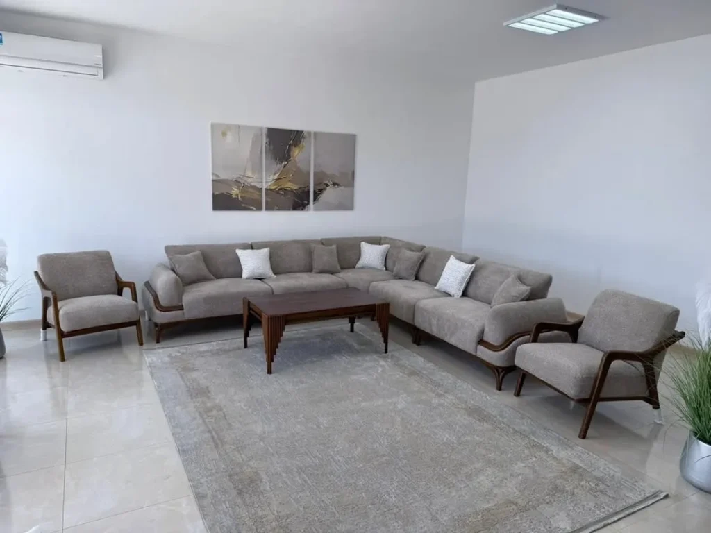 Elegant neutral living room with modern chandelier, beige sofa, and gold accents