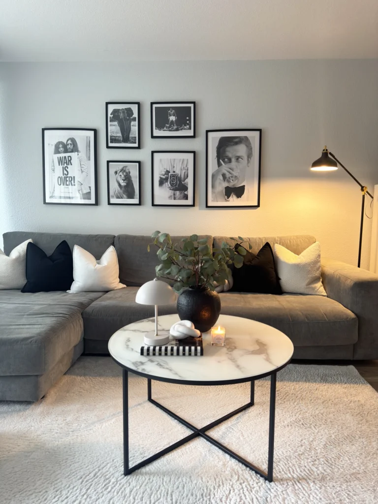 Dark modern living room with black brick wall, industrial lighting, and cozy seating